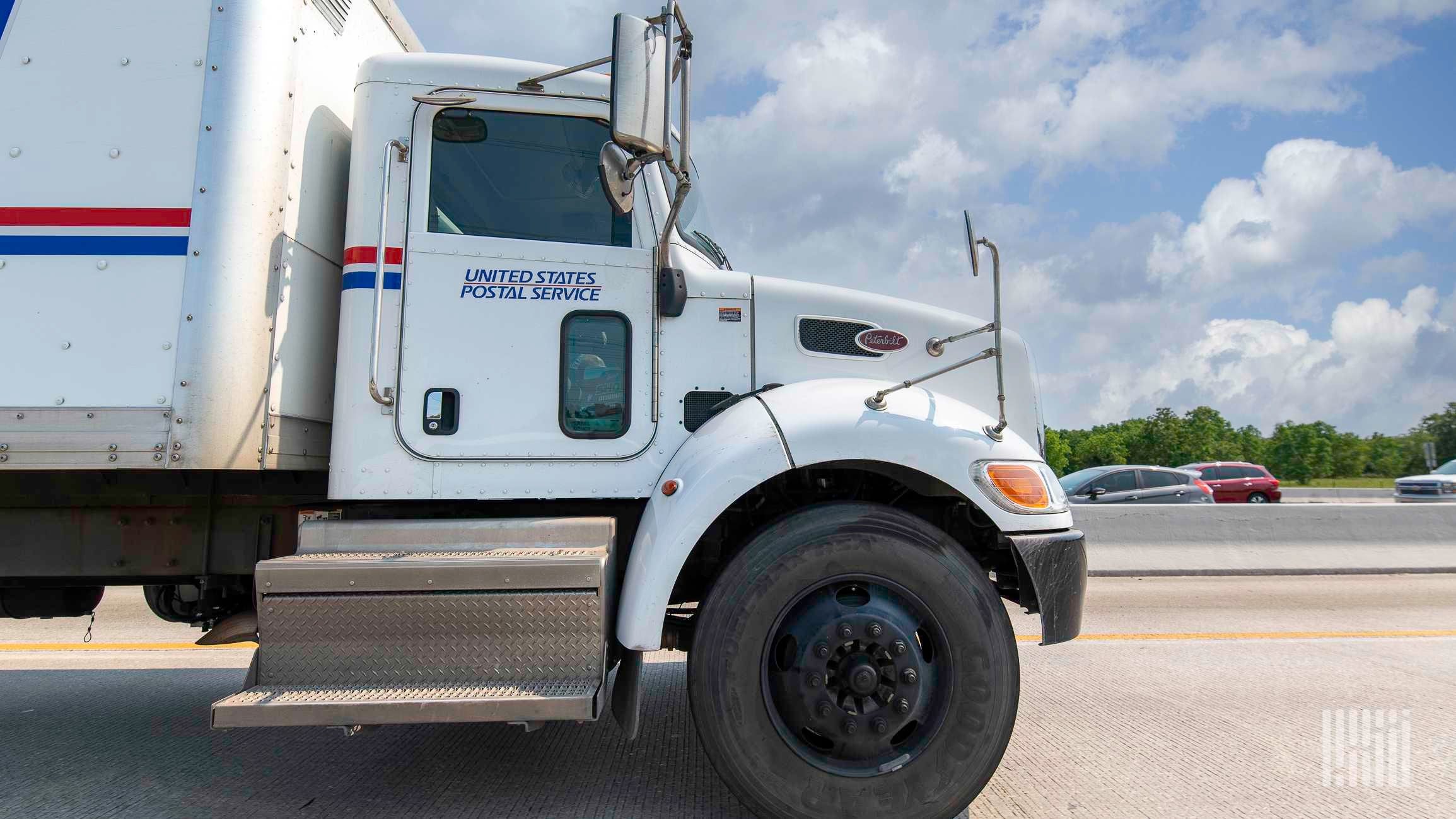 White USPS mail delivery truck on highway